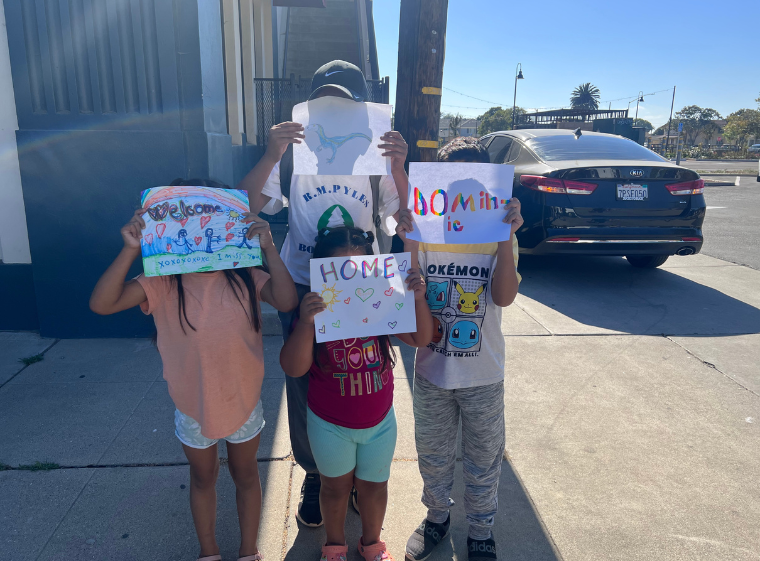 A camper's family greets him with handmade welcome signs upon his arrival.